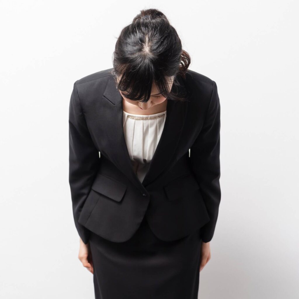 謝罪をするスーツ女性